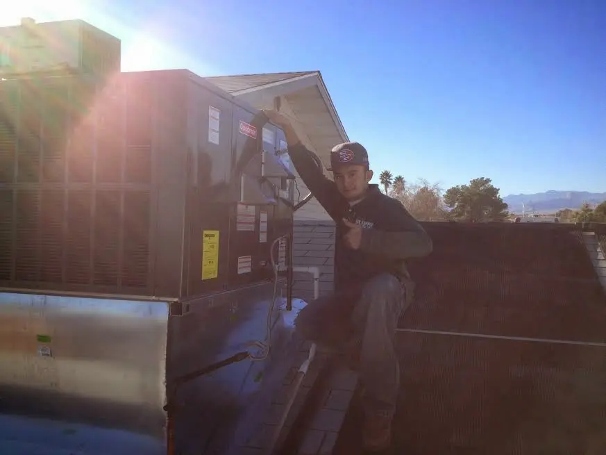 HVAC technician performing HVAC Inspection on a rooftop unit in Tremonton